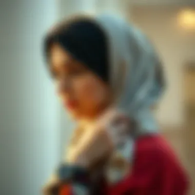 An elegant display of a woman tying a headscarf in a fashionable manner