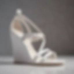 Elegant white strappy wedge sandals displayed on a polished surface.